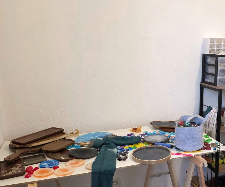 Créations en résine époxy faites main séchant sur la table de l’atelier